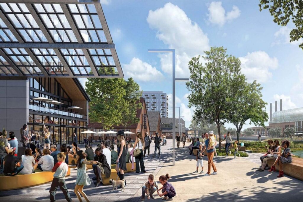 People gather in an outdoor urban plaza with seating, trees, modern buildings, and a glass canopy under a partly cloudy sky, set within the all-electric mixed-use development near North Temple Jordan River.