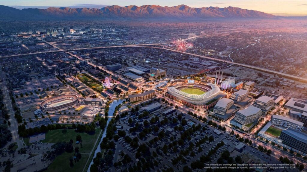 Aerial view of a large sports stadium complex at sunset near North Temple Jordan River, surrounded by city streets, buildings, and mountains. Fireworks light up the sky above the stadium.