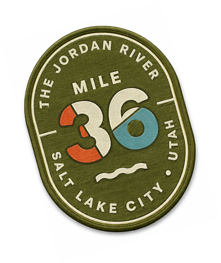 Un parche bordado dice "The Jordan River Mile 36 Salt Lake City Utah" con un número 36 estilizado en rojo, blanco y azul, perfecto para celebrar el distrito de negocios del oeste de Salt Lake.