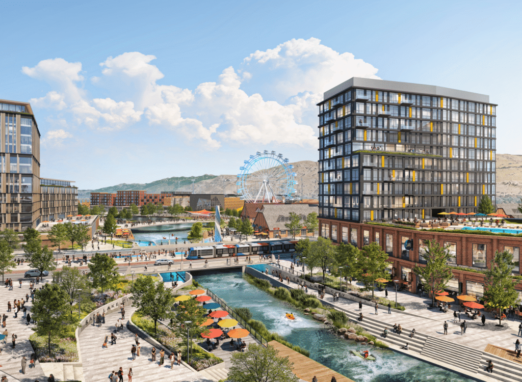Modern urban district with mid-rise buildings, a river, pedestrian walkways, greenery, a bridge, outdoor seating areas, and a Ferris wheel—an all-electric mixed-use development shaping the vibrant Salt Lake westside business district under a blue sky.