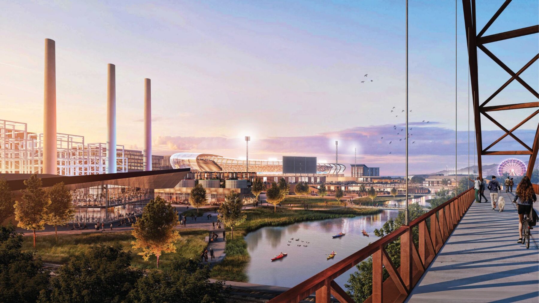 La gente camina por un puente que domina el distrito comercial del lado oeste del Salitrero, con un estadio, chimeneas industriales, kayakistas en el río y una rueda de la fortuna a lo lejos al atardecer.