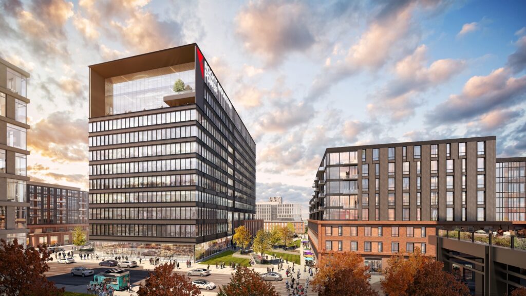 Modern office and residential buildings with glass facades form an all-electric mixed-use development near North Temple Jordan River, set in an urban area with trees, cars, and people, under a partly cloudy sky at sunset.